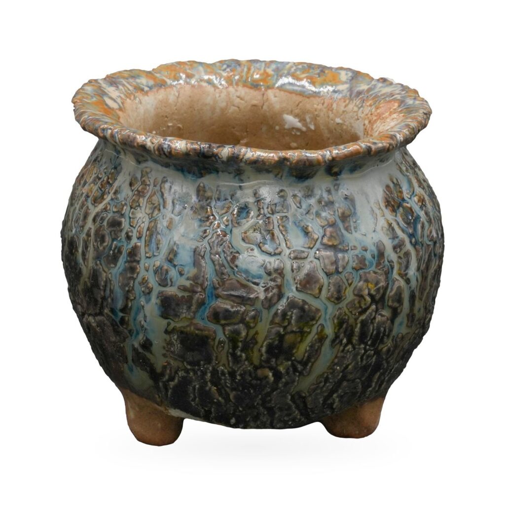 Round footed pot in dark teal and charcoal crackle glaze with a textured rust and blue rolled rim